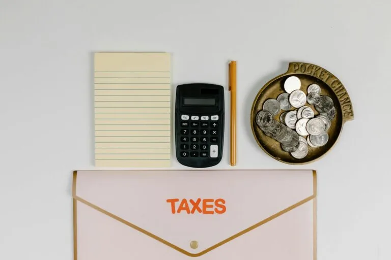 Auto de Infração: Como Impugnar Administrativamente 7 A flat lay of tax preparation essentials: calculator, coins, notepad, pen, and folder.