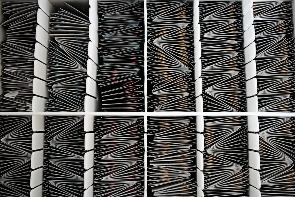 Sou idoso de baixa renda e nunca contribui ao INSS. Tenho direito ao BPC/LOAS? 1 Top view of neatly organized documents divided by separators in a container.