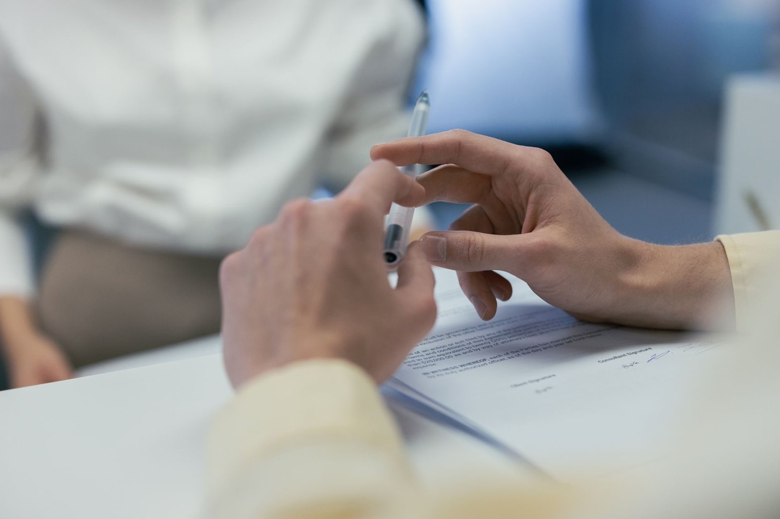 Comissao de corretagem: quem paga e quando ela e realmente devida 1 Close-up of hands holding a pen during a business meeting or contract signing.