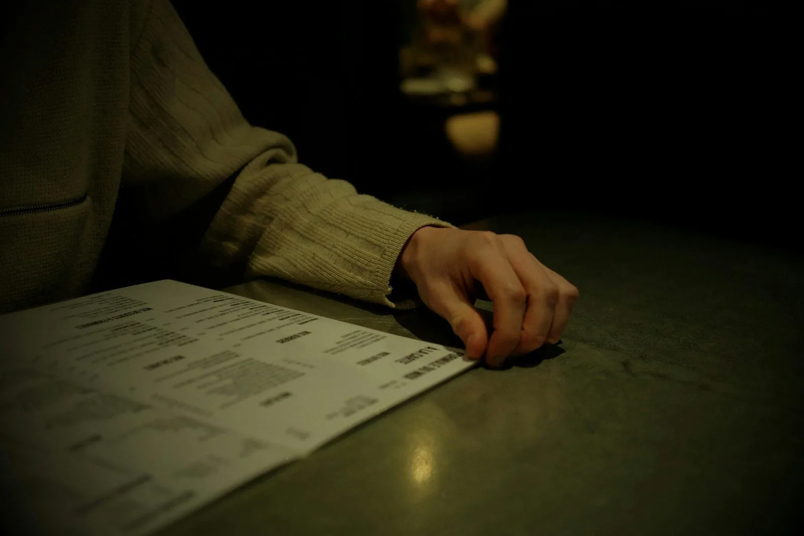a persons hand resting on a piece of paper
