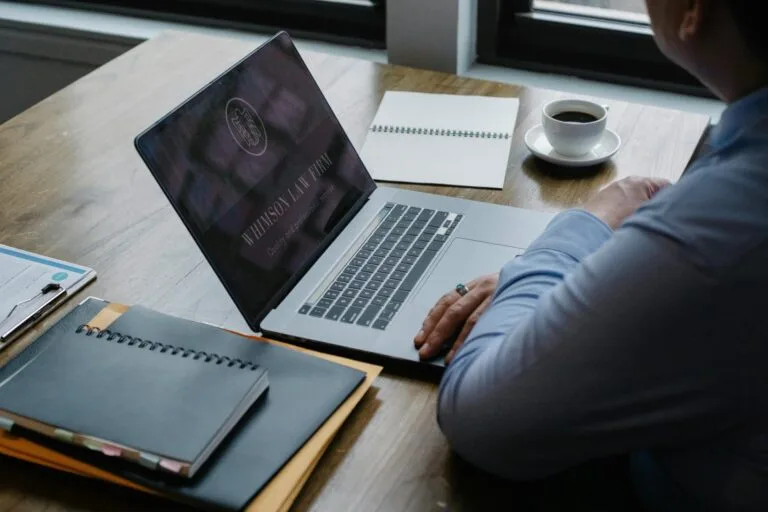 Compliance Empresarial: Programas de Integridade 4 From above of crop anonymous businessman using netbook while sitting at table with documents and cup of hot coffee