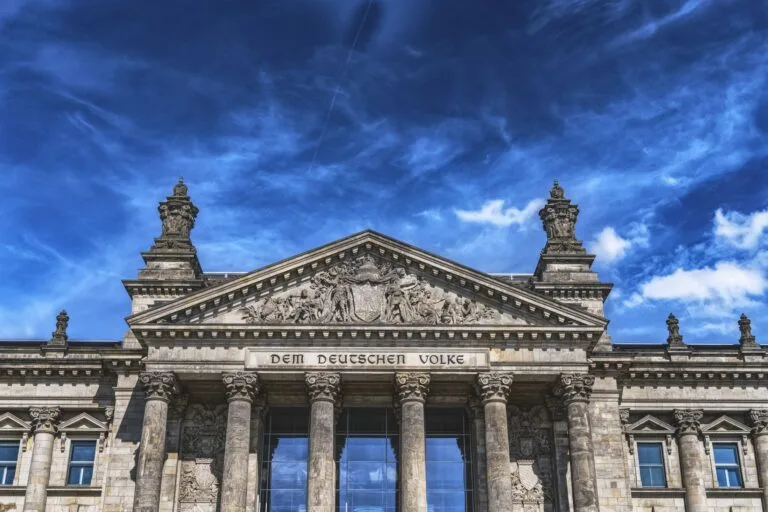 Low angle view of the iconic Reichstag building in Berlin with clear blue skies.