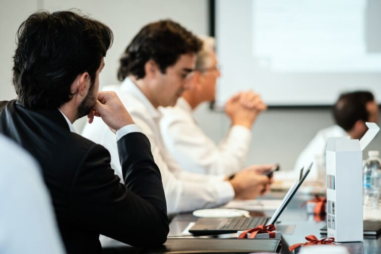 Corporate professionals in a formal meeting environment, focused on teamwork and collabora