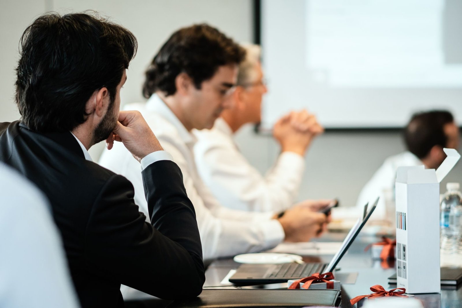 Corporate professionals in a formal meeting environment, focused on teamwork and collabora