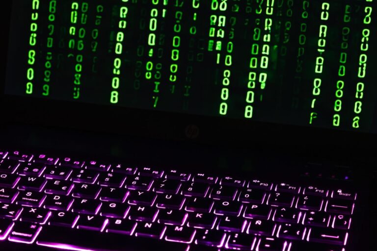 Contrato eletronico e assinatura digital: quando o aceite online tem validade 6 Illuminated laptop keyboard with Matrix-style green code cascading down screen.