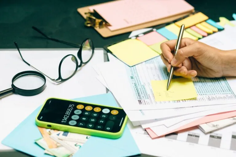 Autônomo calculando a contribuição do INSS com documentos e calculadora sobre a mesa