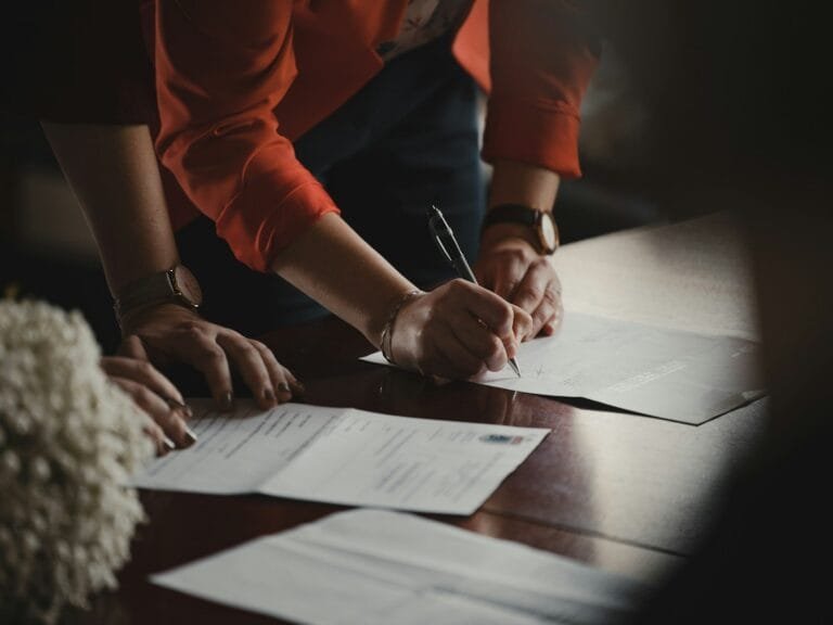 Decreto 3.048/99: Entenda o Regulamento da Previdência 4 person in orange long sleeve shirt writing on white paper