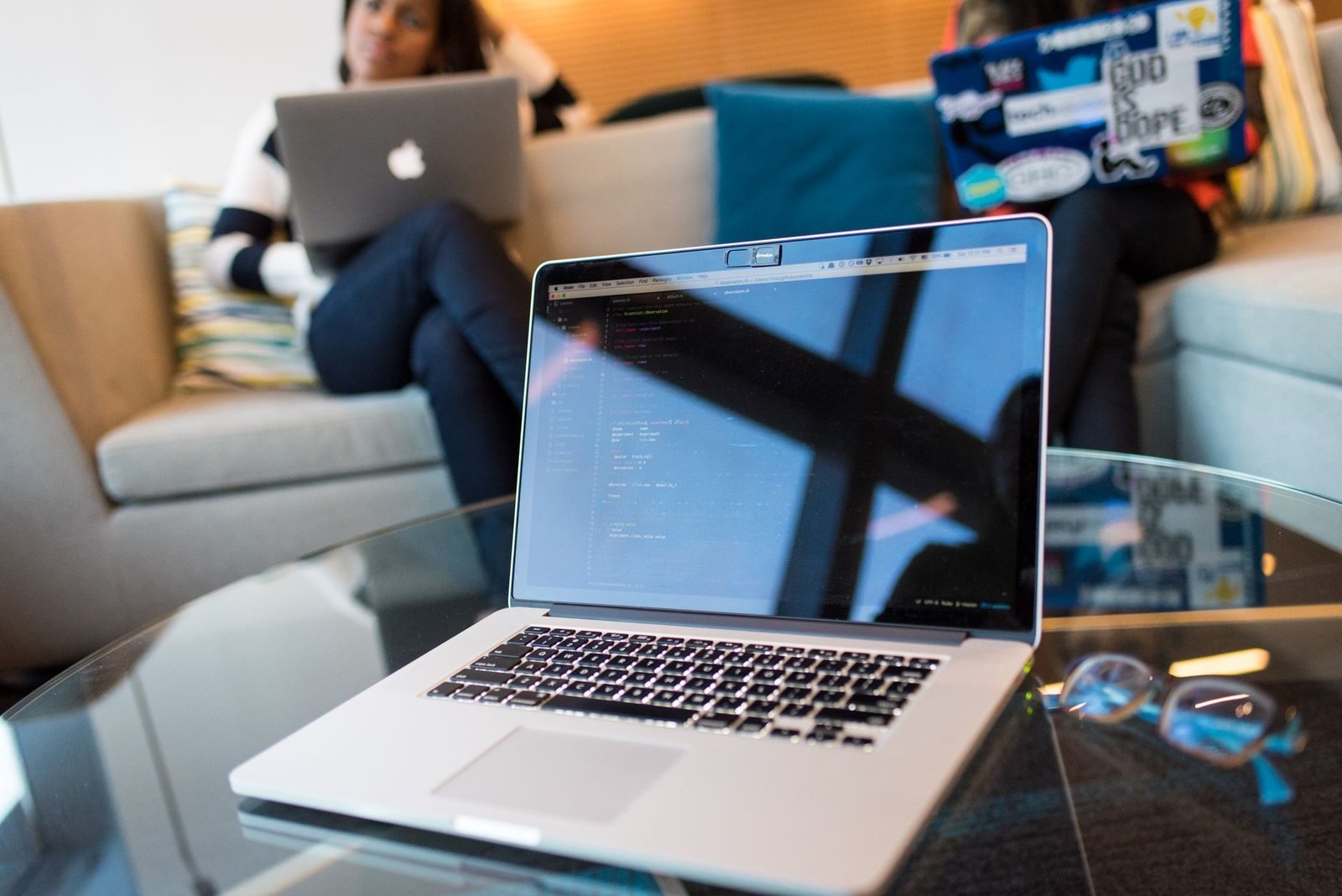 Difamacao em grupos e redes: como pedir a retirada e responsabilizar quem ofende 1 Two people working on laptops in a modern office setting. Technology focus.