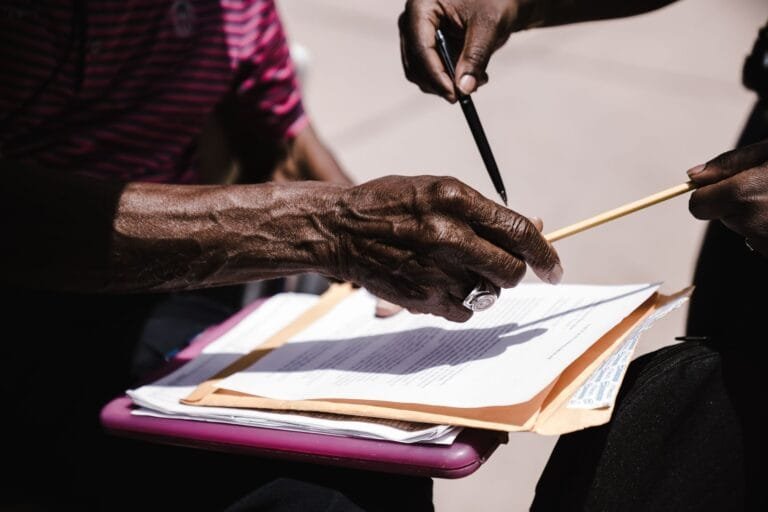 Direito de petição e recurso administrativo: como questionar atos da administração 8 Close-up of hands exchanging documents with pens outdoors. Business agreement concept.