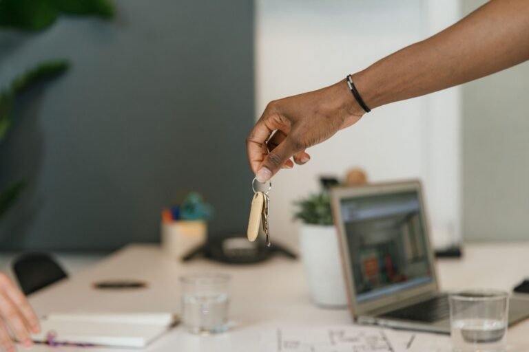 Distrato imobiliario: quanto a construtora pode reter quando o comprador desiste 5 Close-up of a handshake exchanging keys in an office setting.
