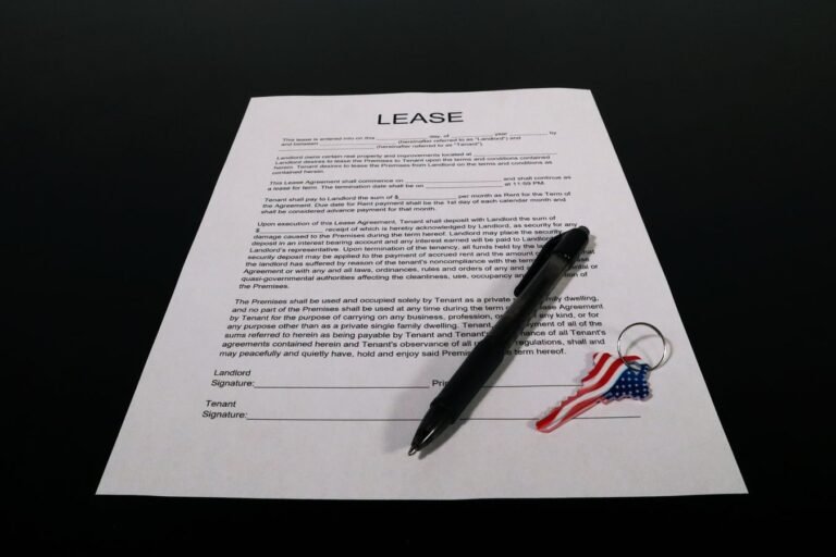 Distrato imobiliario: quanto a construtora pode reter quando o comprador desiste 4 Lease agreement document with pen and American flag keychain on a black table.