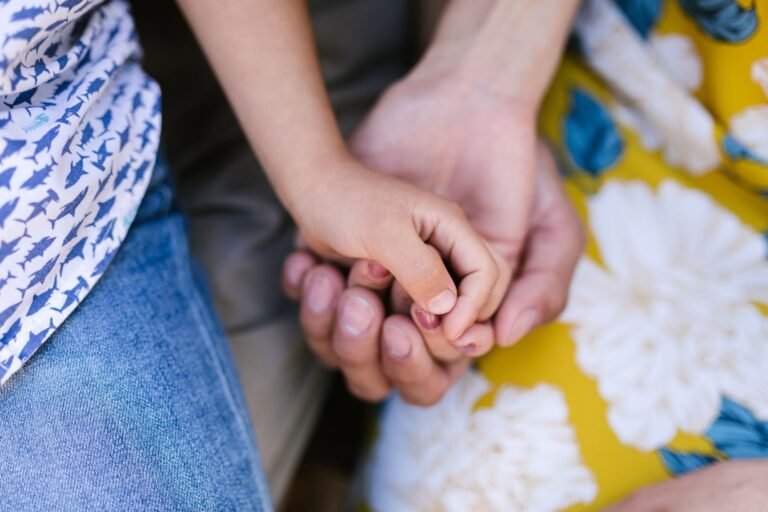 Divórcio consensual e litigioso: caminhos, prazos e cuidados na separação 4 A touching close-up of a child's hand holding an adult's, symbolizing family bond.