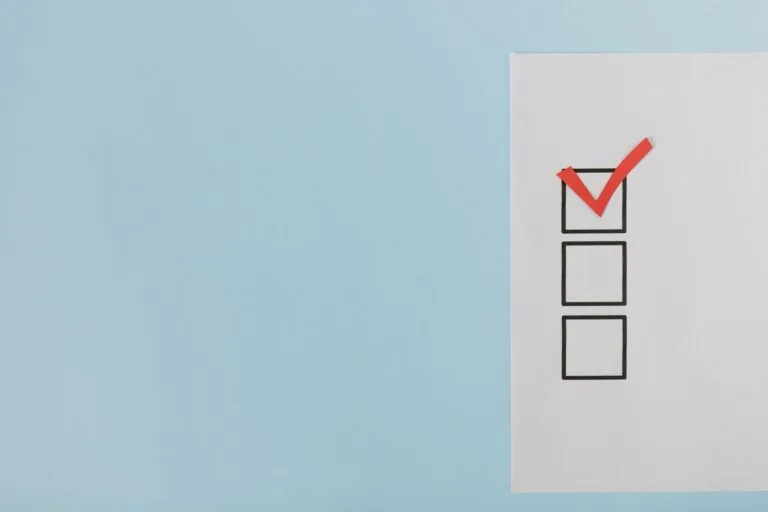 Documentos essenciais antes de requerer a aposentadoria: um checklist prático 3 A minimalist checklist with a red checkmark on a blue background, providing ample copy spa