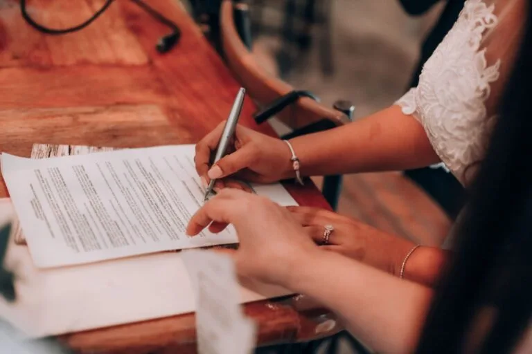 Estabilidade do servidor público: quando ela começa e o que pode rompê-la 4 Hands signing an important document at a wooden table, symbolizing agreement and commitmen