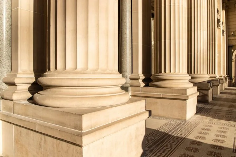 Close-up view of classical stone columns in sunlight, showcasing architectural beauty.