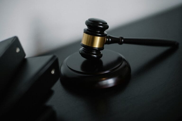 Feminicidio de militar vai ao juri, decide STJ 5 High angle of shiny wooden ceremonial mallet with golden detail placed on judge tale near documents folders