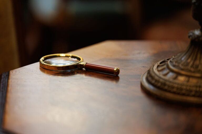A vintage-style magnifying glass placed on a polished wooden table, exuding an elegant and