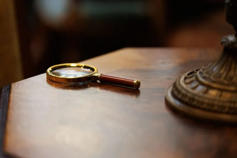 Furto e roubo não são a mesma coisa: entenda a diferença 7 A vintage-style magnifying glass placed on a polished wooden table, exuding an elegant and