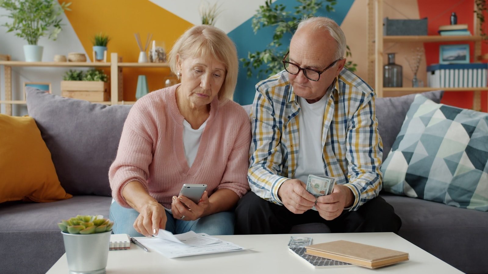 Governo inicia ressarcimento de descontos indevidos a aposentados e pensionistas do INSS após acordo homologado pelo STF, com pagamentos a partir de 24 de julho 1 Elderly couple looking at bills and phone