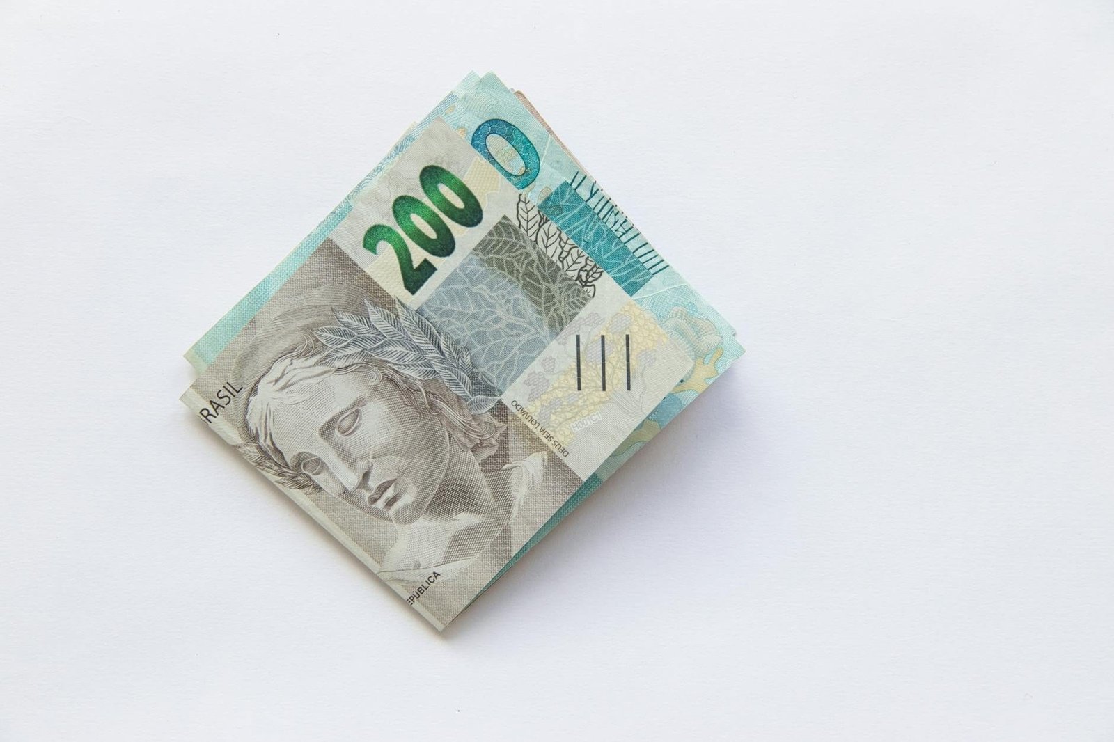 Stack of 200 Brazilian Real banknotes isolated on a white surface, symbolizing w