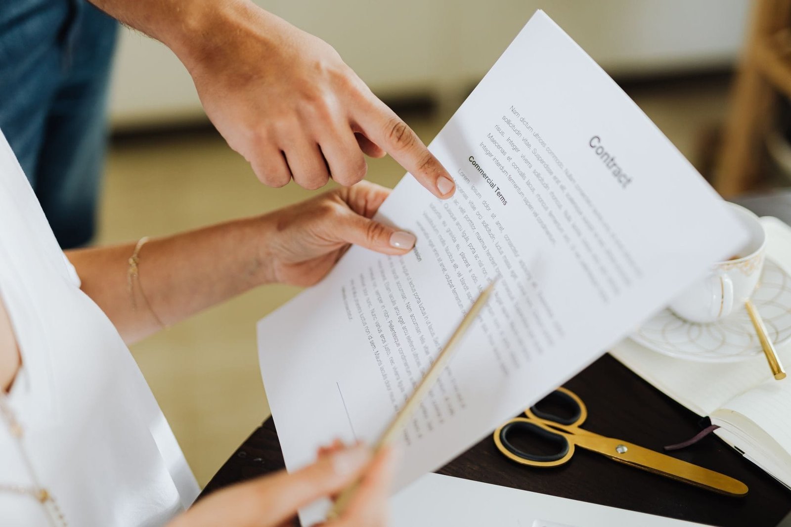 Close-up of two people discussing a business contract at a desk in an office set