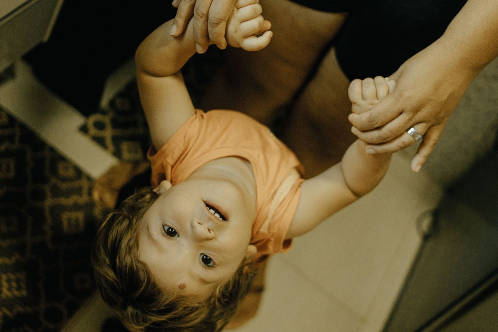 Alienação parental: como o Judiciário identifica, pune e reverte o afastamento dos filhos 1 A happy child holds hands with a parent indoors, expressing excitement and conne