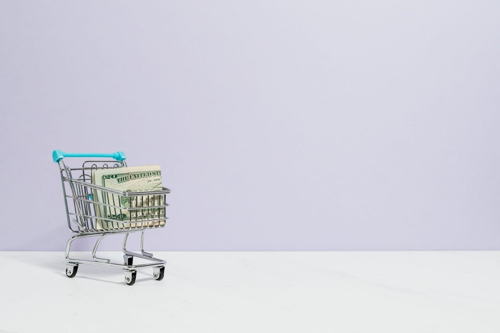 Shopping cart filled with cash on a plain background, ideal for finance and reta