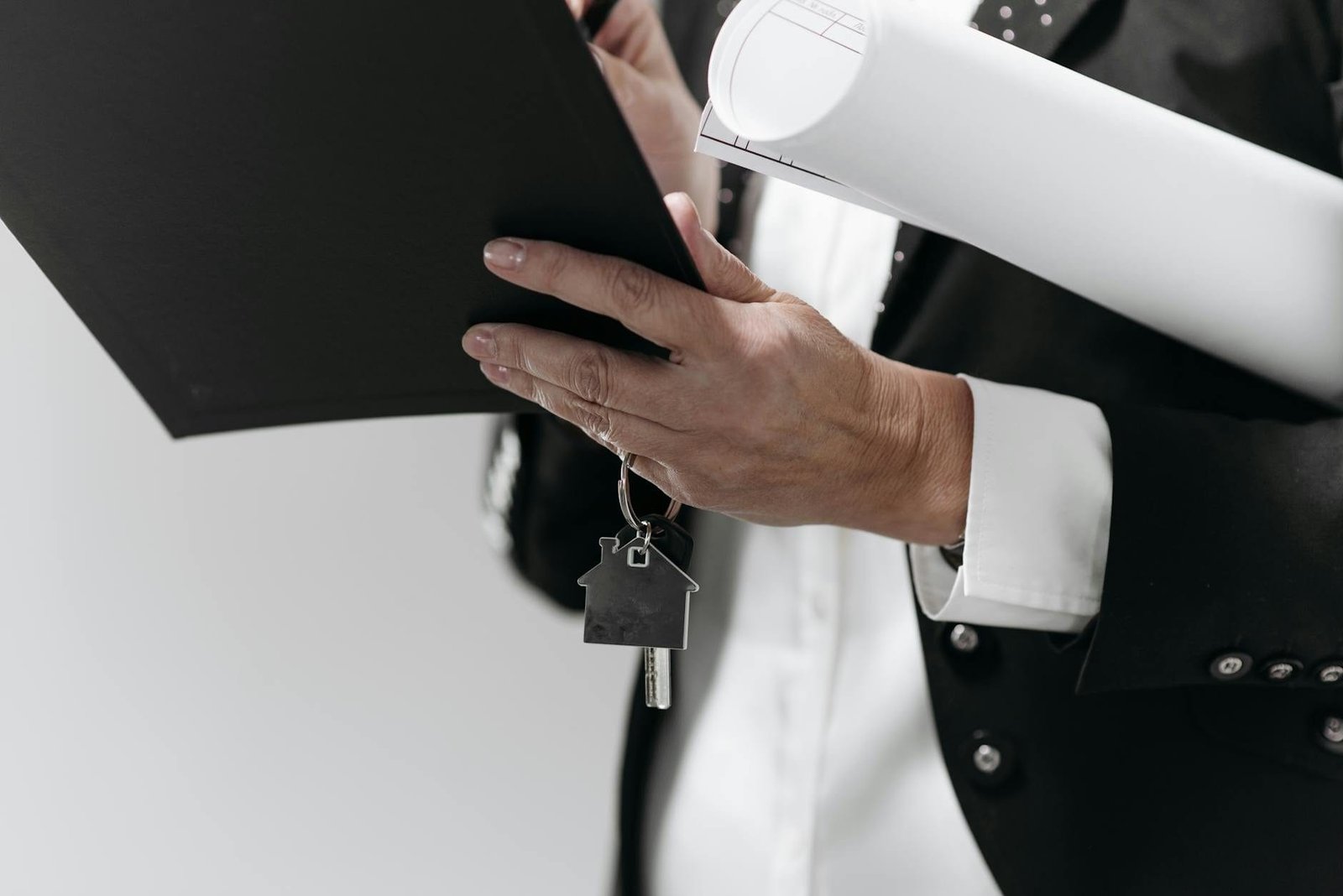 Adjudicação compulsória extrajudicial: como registrar o imóvel sem o vendedor 1 Close-up of a business professional holding a house key and architectural plans,