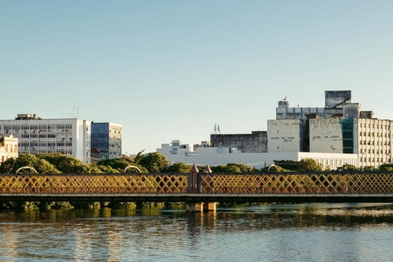 Colaboração premiada: o que o investigado pode e não pode negociar com o Ministério Público 13 Serene view of a heritage bridge and urban skyline reflecting in calm waters dur