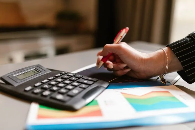 Imunidade e isenção tributária: as diferenças e quem tem direito ao benefício 3 A business professional uses a calculator and documents during a workspace task.