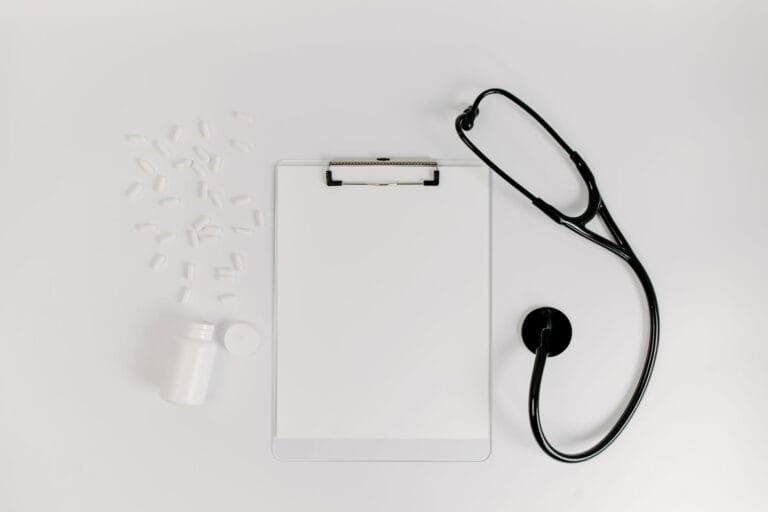Indeferimento do INSS: como entender o motivo e decidir entre recurso e ação 5 Flat lay of clipboard, pills, and stethoscope for medical use.