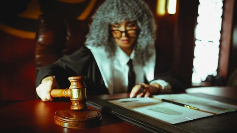 Inquérito Policial: Direitos do Investigado 5 Female judge in a courtroom setting, focusing on legal documents with a gavel.