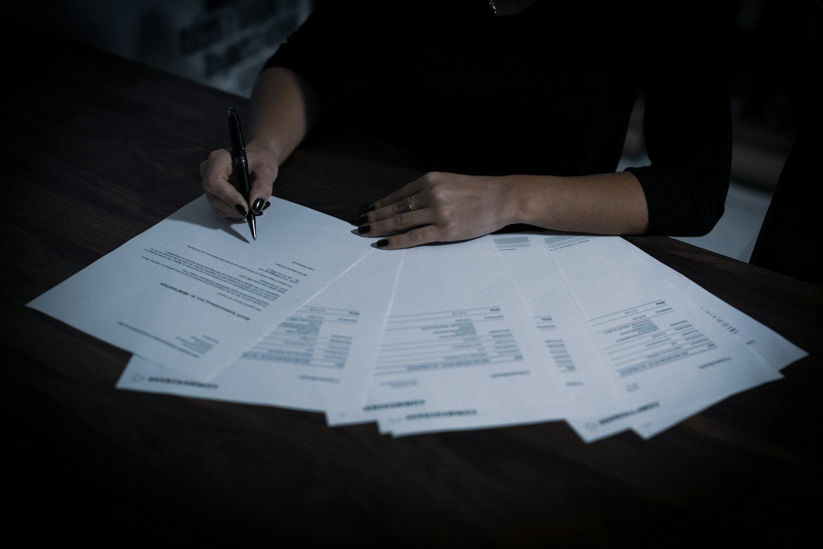 INSS Nomeia 75 Analistas e Autoriza Mais 225 em 2026 1 a woman sitting at a table with lots of papers