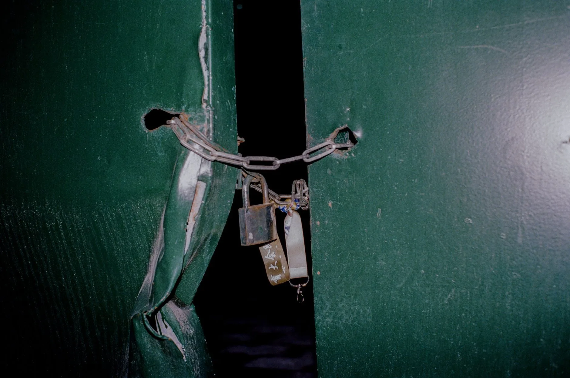Interdição e fechamento de estabelecimento pela fiscalização: direitos do empresário 1 Close-up of a rusty padlock and chain securing green metal doors, blocking entry.
