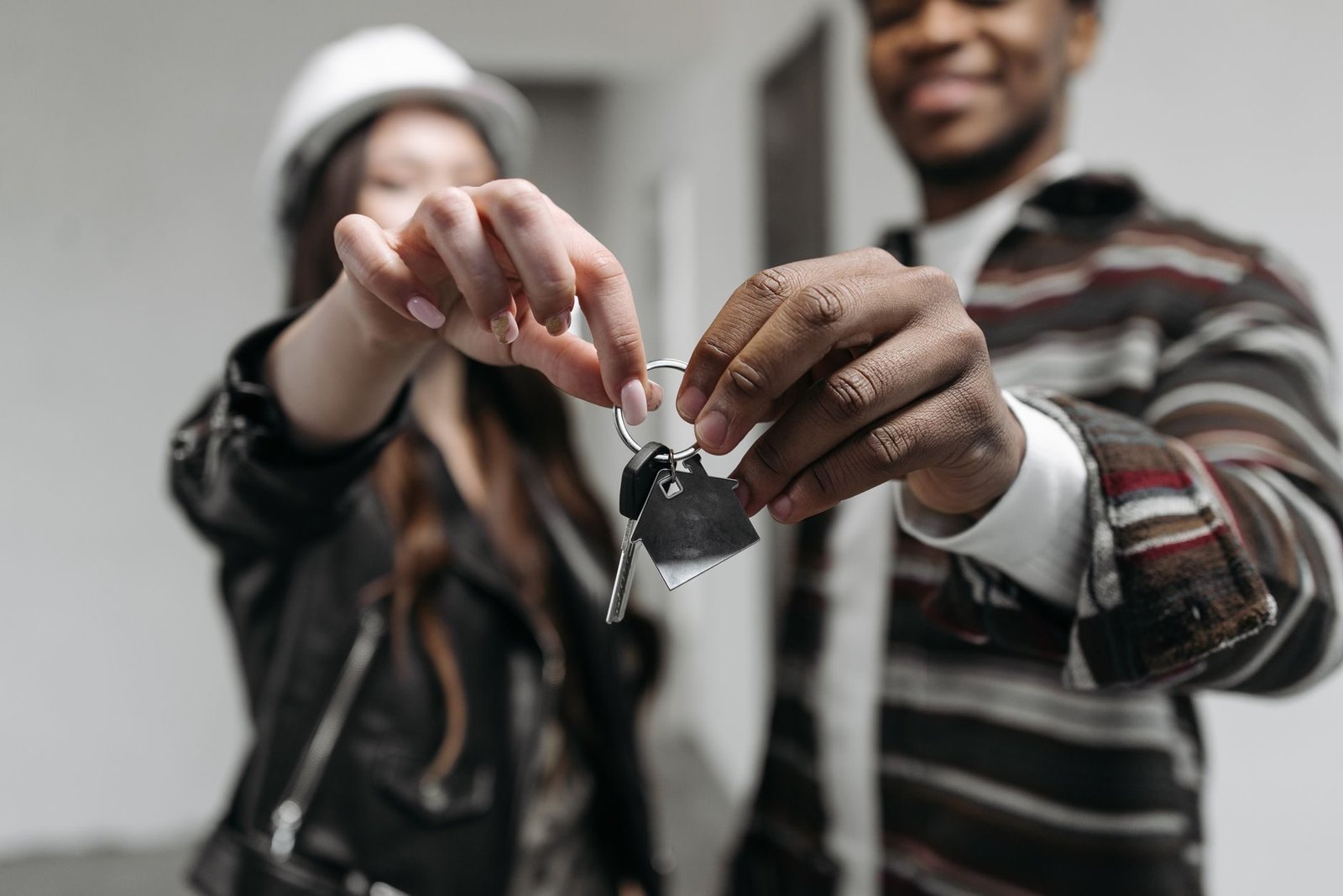 Close-up of a couple joyfully holding keys to their new home, symbolizing new beginnings a
