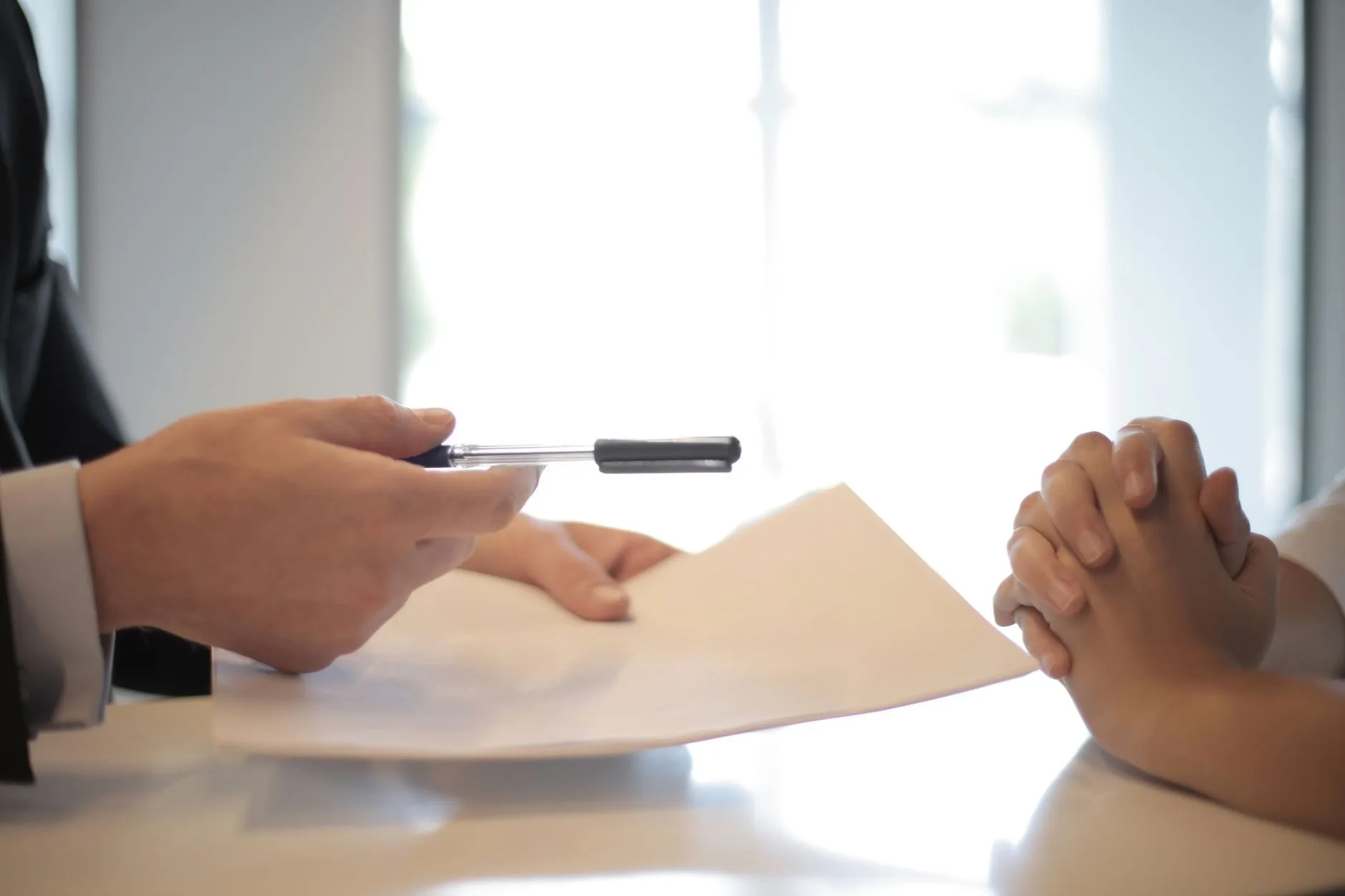 Licenças e alvarás: como funciona a autorização do Estado para abrir e manter um negócio 1 Side view of faceless formal man giving pen and paper to focused female with clenched hand