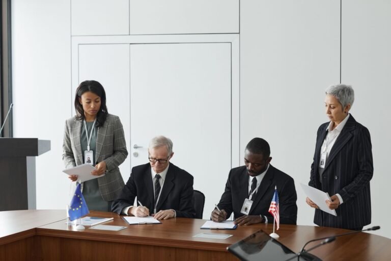 Business leaders signing a significant agreement in a conference room setting.