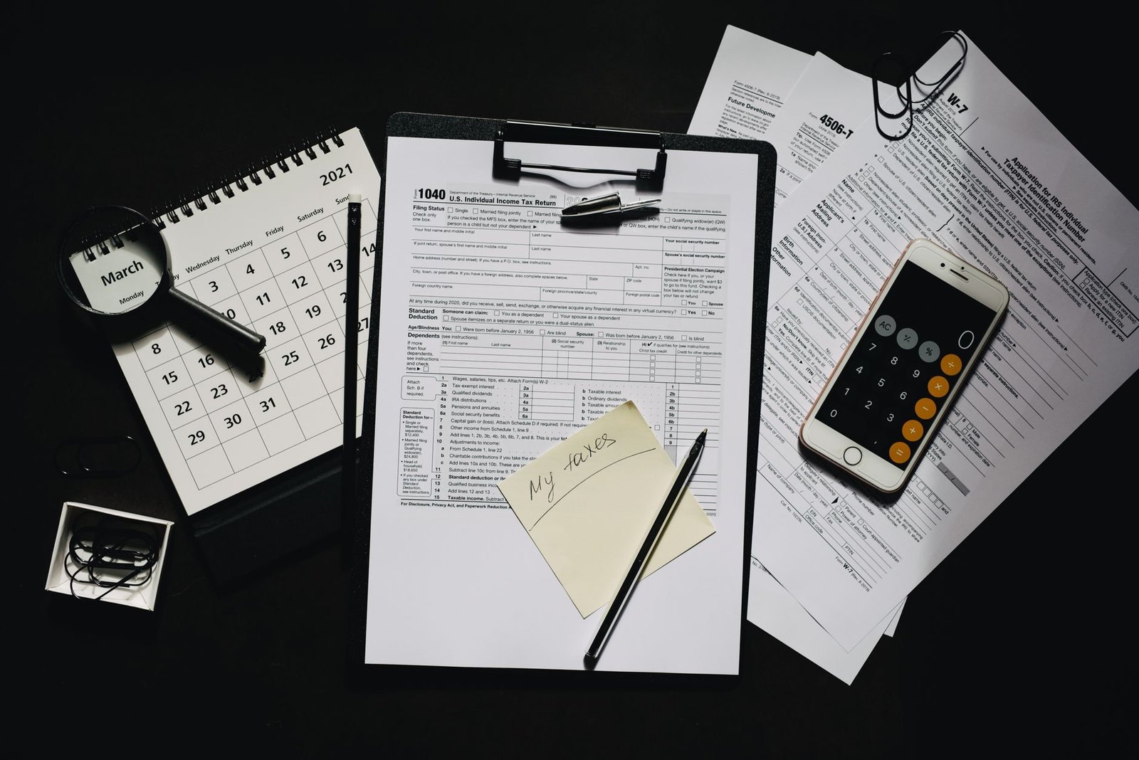 Multas tributarias abusivas: como questionar penalidades com efeito de confisco 1 High angle view of tax forms, calculator, calendar, and pen for financial planning.