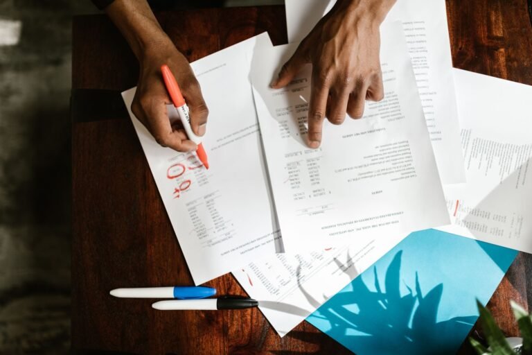 Novo Atestmed amplia para até 90 dias a duração do auxílio por incapacidade temporária concedido por análise documental 2 Overhead view of hands highlighting financial documents on a desk.