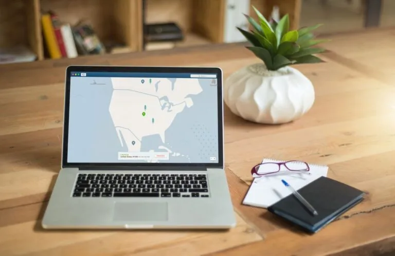 O papel do encarregado de dados e quando a empresa precisa nomear um 6 A laptop displaying VPN software sits on a wooden desk with a notepad and plant offering a secure workspace vibe.