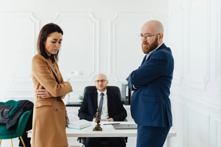 O que esperar de uma sessão de mediação: o passo a passo para quem nunca participou 14 A couple in corporate attire seeks mediation during a business disagreement in an office setting.