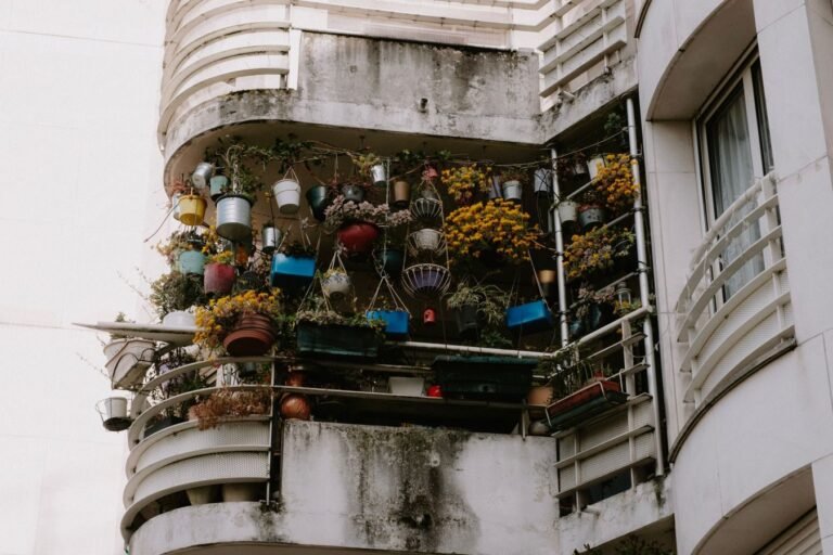 Low angle view of a balcony brimming with vibrant potted plants on a building exterior.