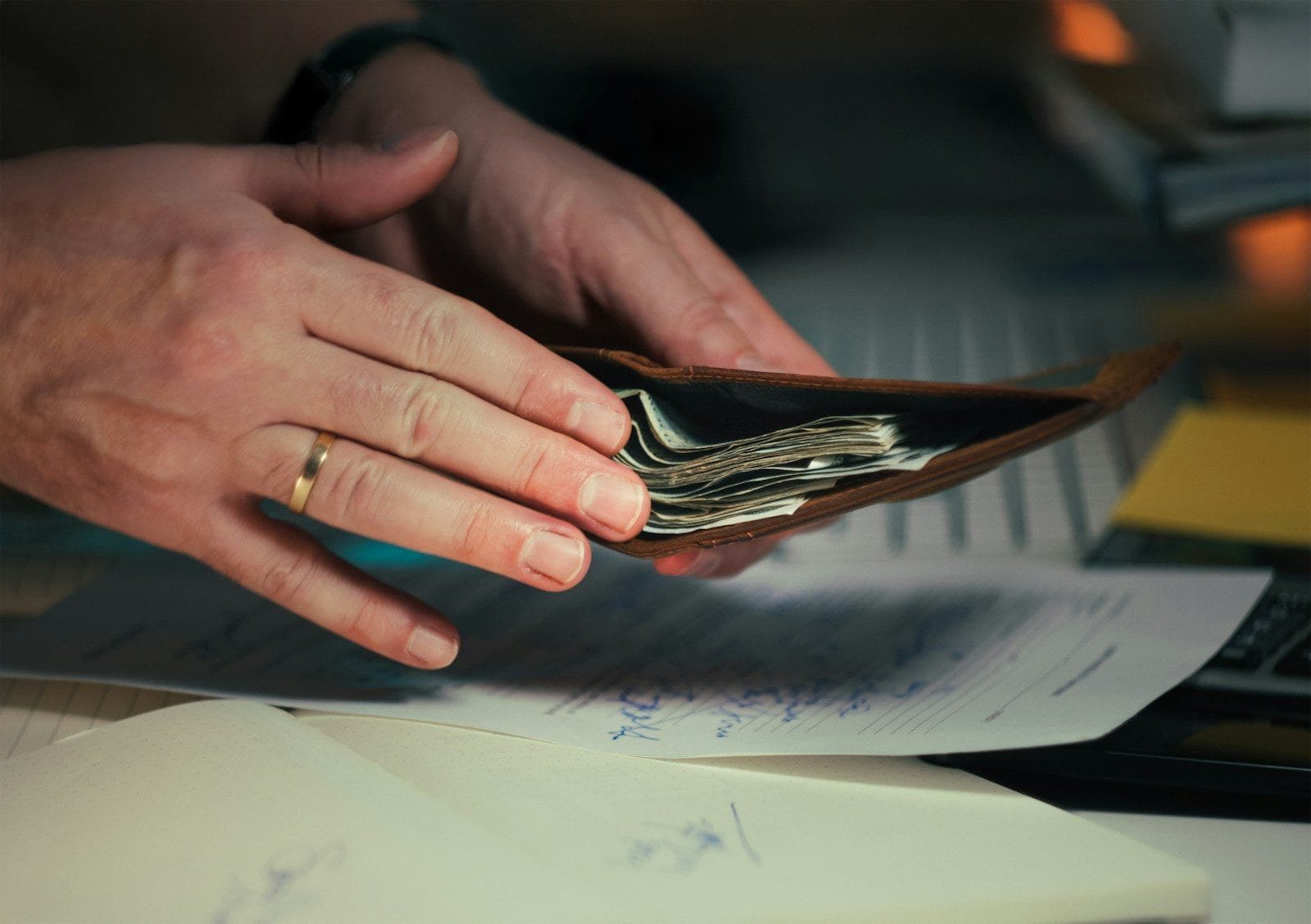 Pagamento INSS Abril 2026: Calendário Por Final do Cartão 1 Hands holding cash in a wallet over papers.