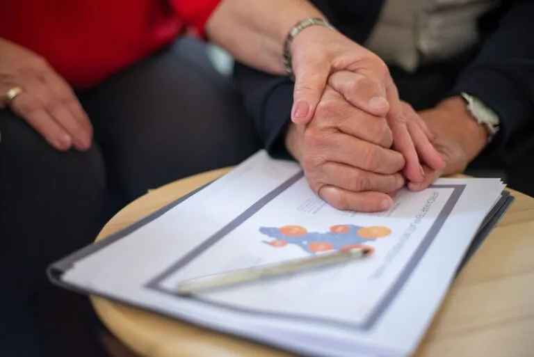 Pensão por morte do trabalhador rural: provas e particularidades do campo 1 Two adults holding hands over business documents, symbolizing support and partnership.