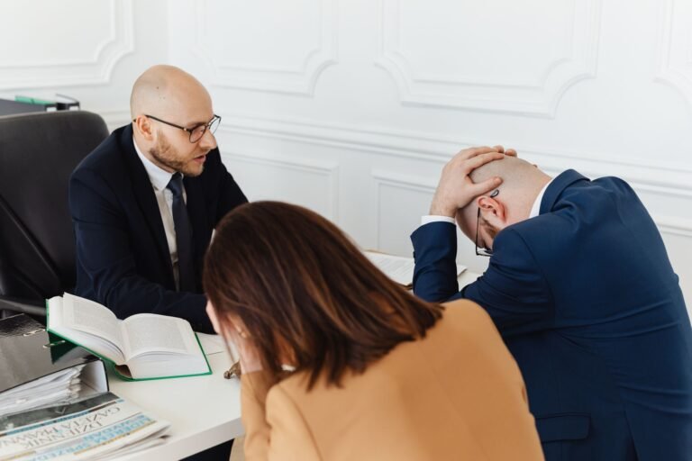 Legal professionals engaged in a tense meeting at a law office with open documents on the 