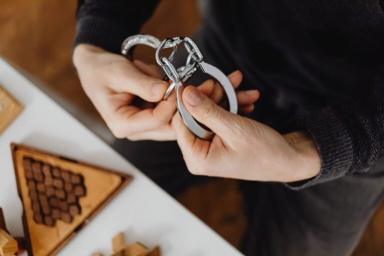 PF e CGU deflagram nova fase da Operação Sem Desconto com 31 mandados de busca em quatro unidades da federação 4 Person carefully handling silver handcuffs indoors, close-up view.