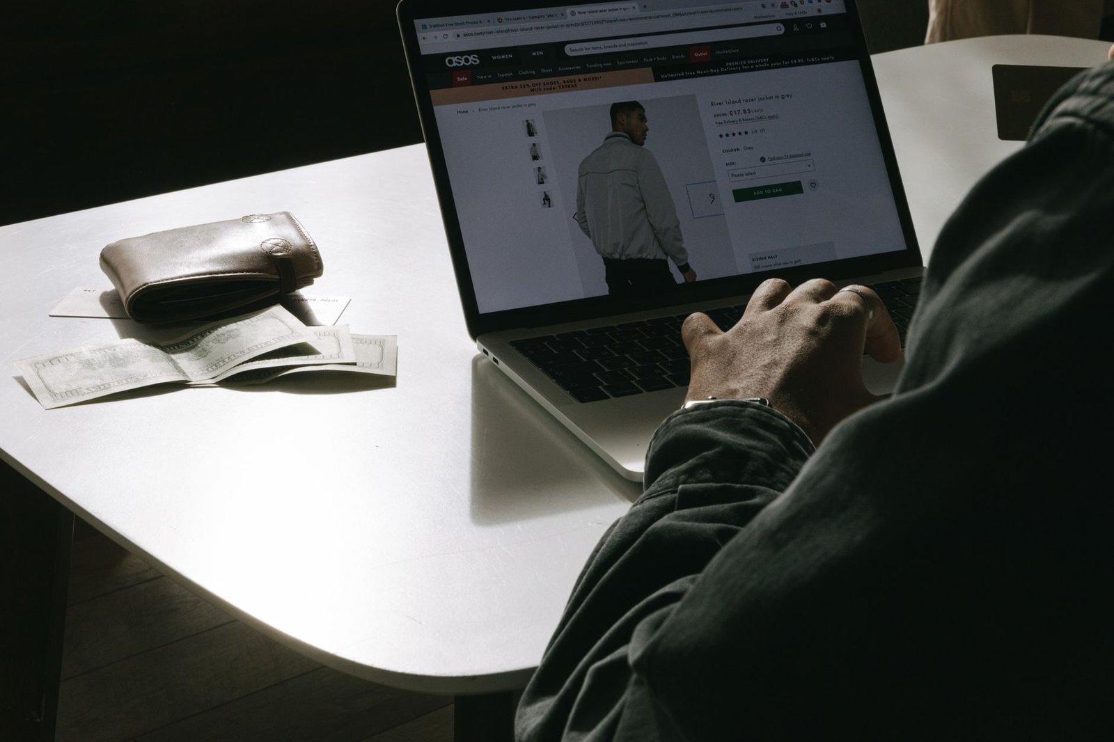 Plano de saúde negou cobertura: quando a recusa é ilegal 1 Adult man shopping for clothes online at home using a laptop, with a wallet on the table.