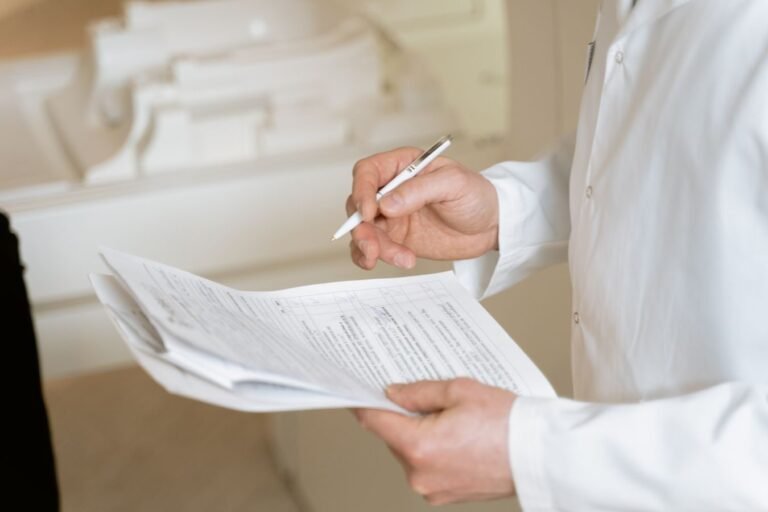 Portaria Conjunta MPS/INSS nº 83/2025 amplia para até 60 dias, com vigência de 120 dias, o auxílio por incapacidade concedido por análise documental 7 A doctor holds and reviews medical documents, demonstrating careful examination and professionalism.