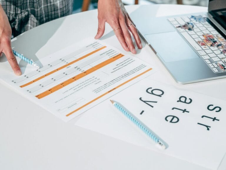 Princípios da Seguridade Social: Guia Completo 2026 6 Close-up of hands reviewing business documents and strategy papers on an office desk.