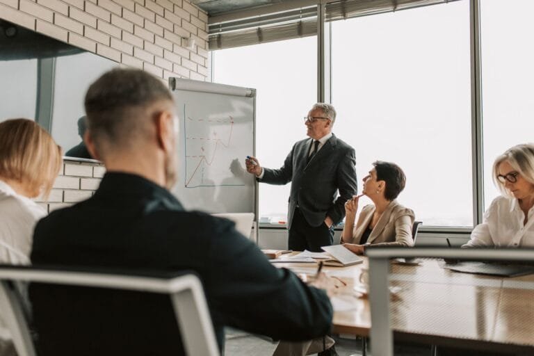 Senior leader presenting growth charts in a business meeting with colleagues in a modern o